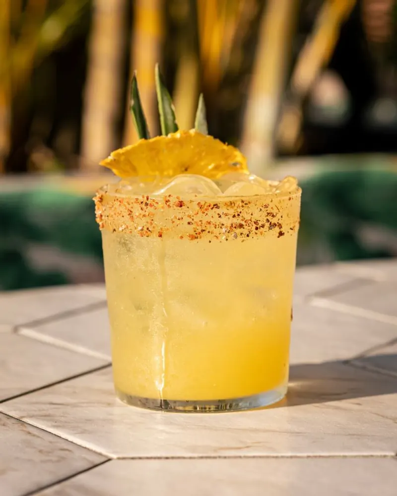 Cóctel tropical con borde de chile y piña deshidratada en Terrat