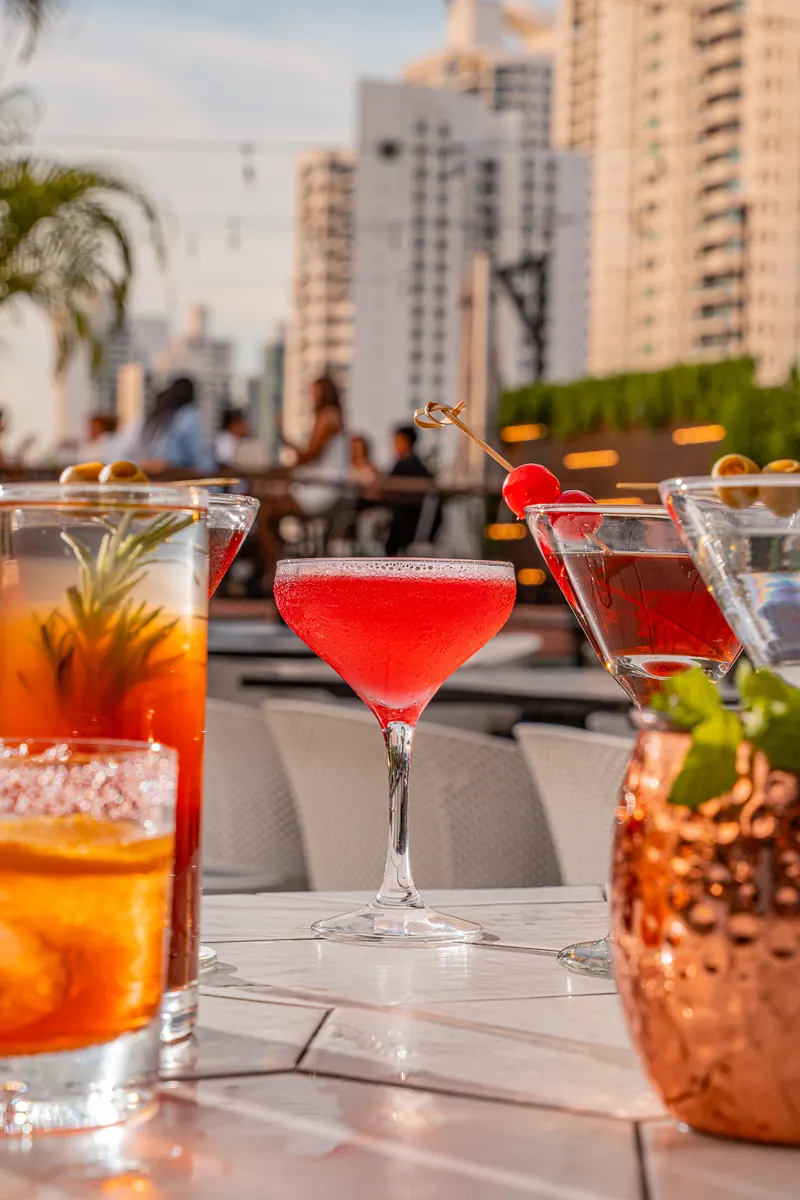 Cócteles del happy hour con la ciudad de fondo en Terrat