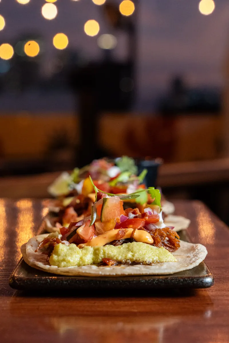 Tacos para compartir en la barra de Terrat con luces de fondo